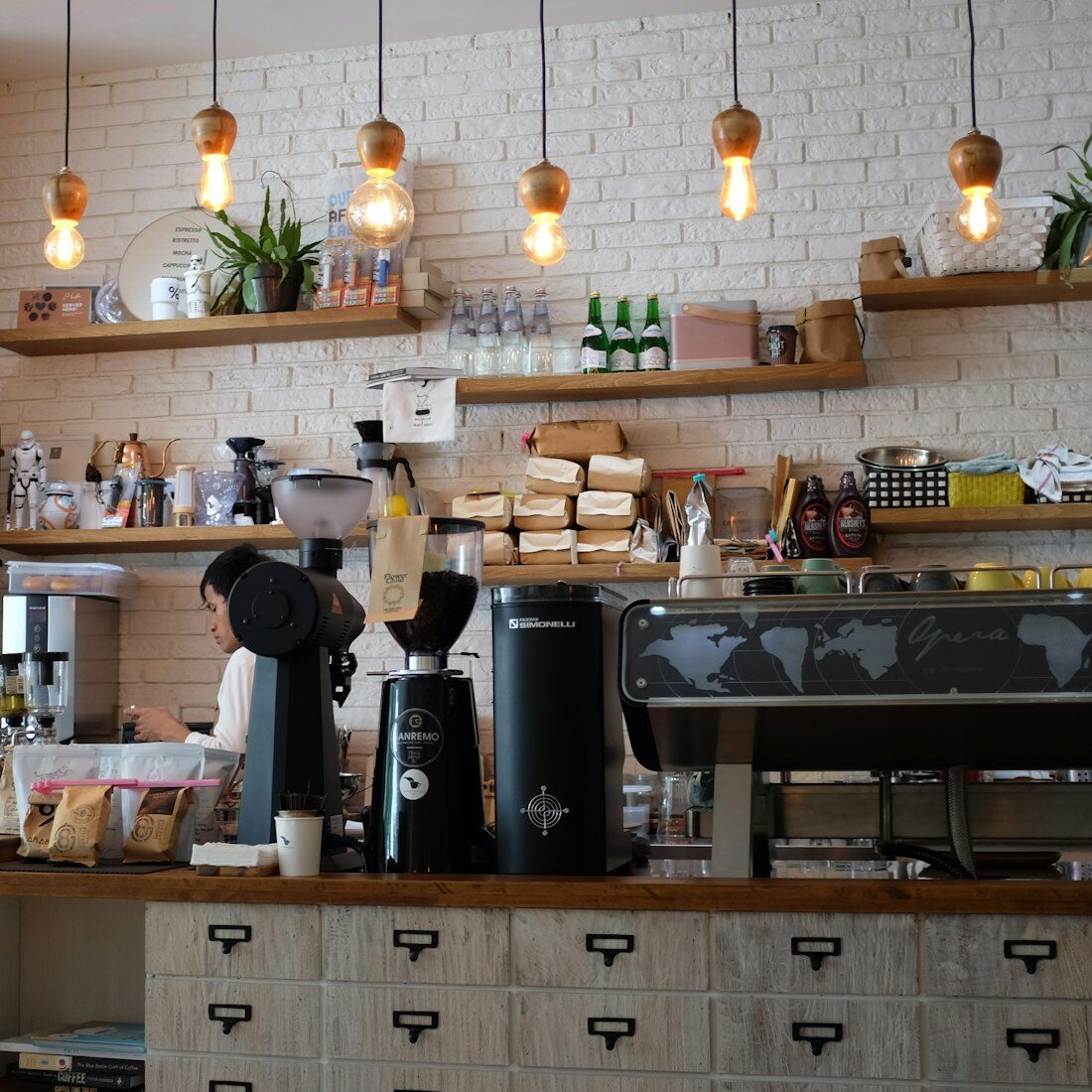 Barista at the counter of a warm, design-led café